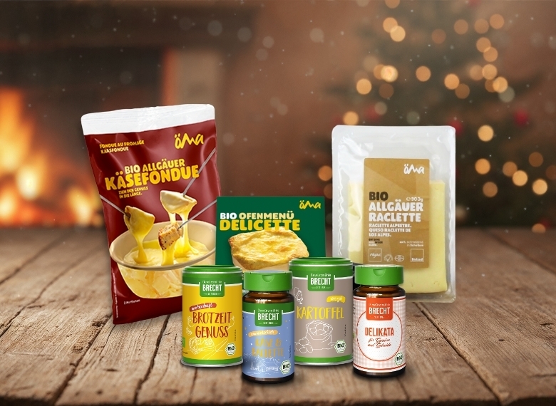 Auf dem Bild sind verschiedene Produkte für Käsegerichte wie Fondue und Raclette sowie einige Beilagen zu sehen.